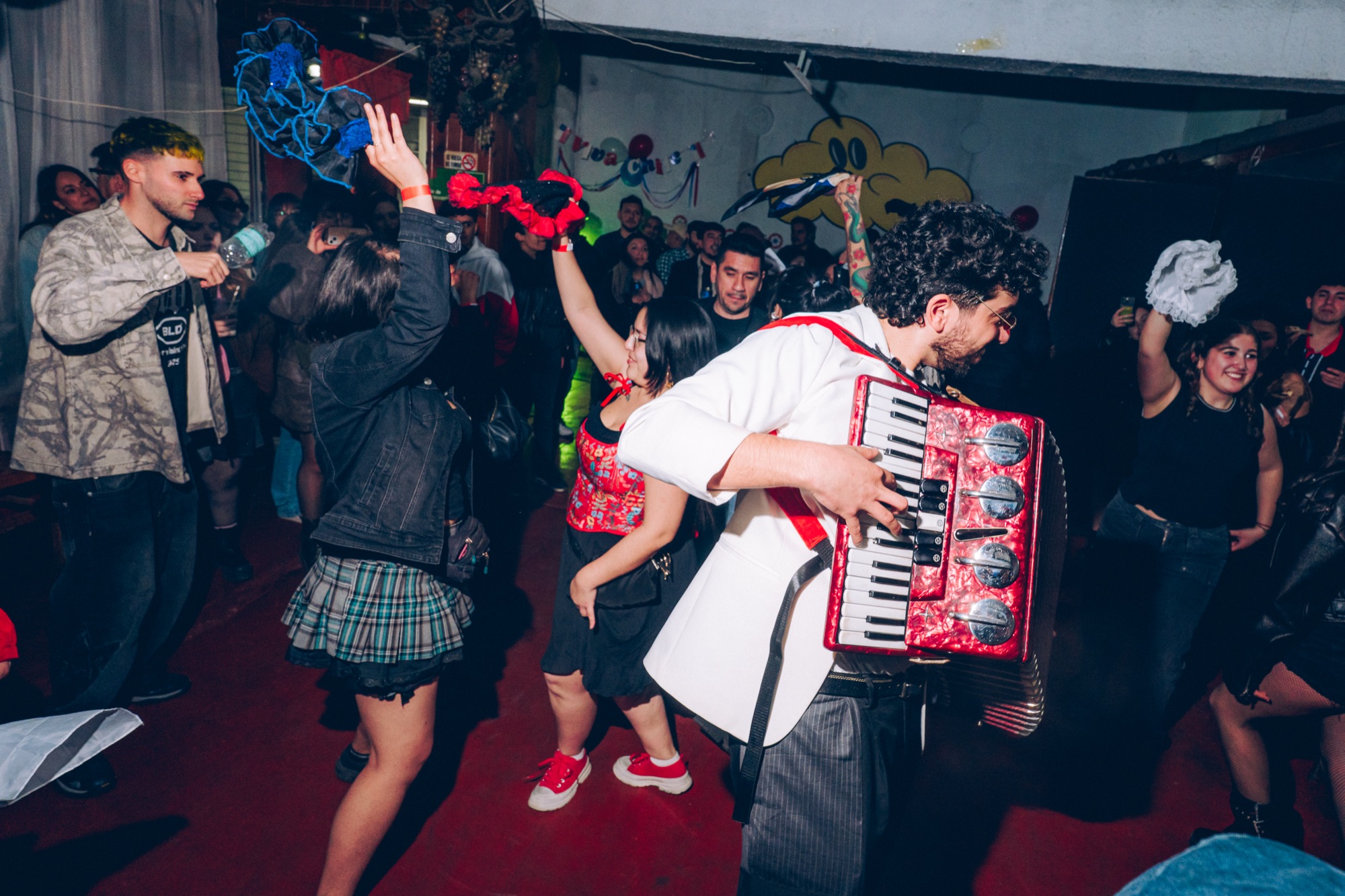 Alan Tiwas tocando acordeón en vivo con gente bailando